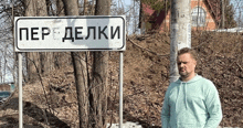 a man is standing in front of a sign that says " per delki "