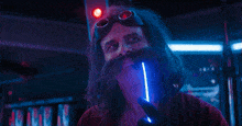 a man in a red shirt is holding a blue light in his hand