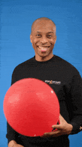a man holding a red balloon wearing a black shirt that says boiling brains