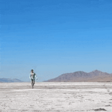 a man in a green shirt and sunglasses is running in the desert .