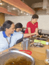 a man and two women are sitting at a table in a restaurant eating food .