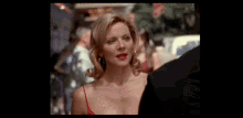 a woman in a red dress is talking to a man in a suit .