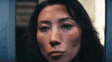 a close up of a woman 's face looking out of a window .