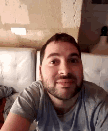 a man with a beard is sitting on a white leather couch