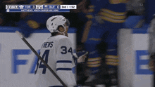 a hockey player with the number 34 on his jersey stands on the ice