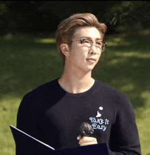 a young man wearing glasses and a sweater that says take it easy