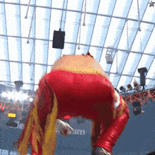 a person in a red and yellow outfit is standing in front of a sign that says " stadium "