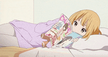 a girl is laying on a bed reading a magazine that says chuve