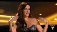 a woman in a strapless dress is standing in front of a screen .
