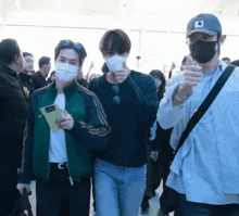 a man wearing a mask is walking with another man