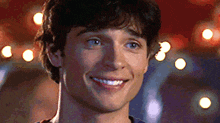 a close up of a man 's face smiling with a blurry background