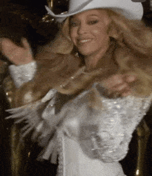 a woman wearing a white cowboy hat and a white dress