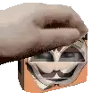 a hand is holding a block with a cartoon face on it .