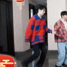 a man in a red and blue plaid sweater is dancing