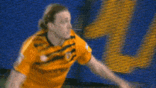 a blurry picture of a soccer player wearing a yellow jersey with the word wolves on it