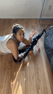 a woman laying on the floor with a gun