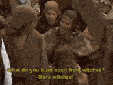 a man in a knight 's armor is talking to a witch who is wearing a horn