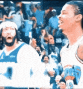 two basketball players are standing next to each other on a court .