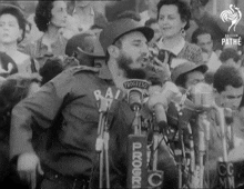 a man stands in front of a microphone with the word progresso on his shirt