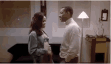 a man and a woman are standing next to each other in a living room