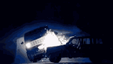 a car is driving down a dark road at night and the headlights are shining brightly .