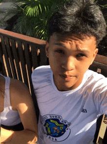 a man wearing a shirt that says ' eb ' on it sits on a bench