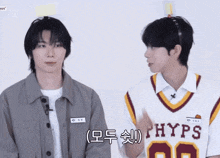 two boys are standing next to each other and one has a phyps jersey on
