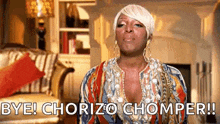 a woman in a colorful dress is standing in a living room and says `` bye ! chorizo chomper ! ''
