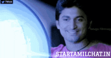 a man in a pink shirt is smiling in front of a starttamilchat.in logo