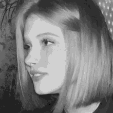 a black and white photo of a woman 's face with a nose ring .