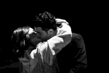 a black and white photo of two people hugging each other