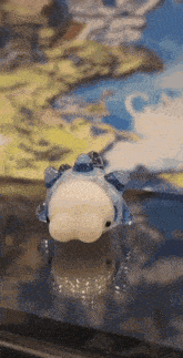 a blue and white figurine is sitting on a table in front of a map