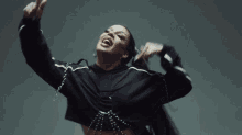 a woman in a black hoodie is making a peace sign with her hands