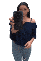 a woman in a blue off the shoulder top is holding up a broken iphone