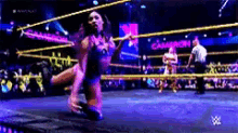 a woman is jumping in the air in a wrestling ring