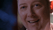 a close up of a man 's face smiling with his mouth open .
