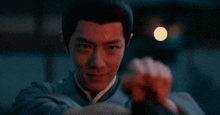 a close up of a man 's face with a fist in the air in the dark .