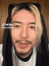 a man with a beard is wearing a black scarf around his head and has a tiktok sticker on his face