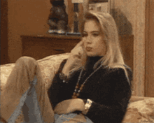 a woman is sitting on a couch talking on a phone