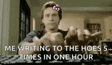 a man is sitting at a keyboard with a pink bow on his head .