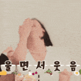 a woman covering her mouth with her hands with korean writing above her head