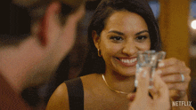 a woman drinking from a shot glass with a netflix logo on the bottom right