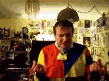 a man in a colorful sweater is dancing in a room with posters on the wall
