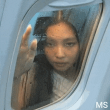 a woman is looking out of an airplane window with ms written on the bottom right