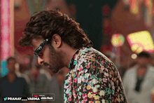 a man wearing glasses and a floral shirt is listening to pranay_varma on youtube music