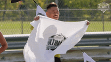 a man holding a white flag that says ultimate on it