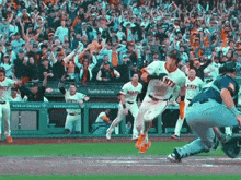a giants player is running towards home plate during a baseball game