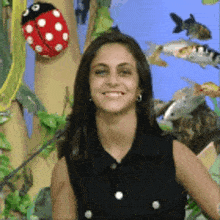 a ladybug is hanging on a tree next to a woman in a black shirt