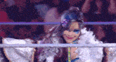 a woman in a costume is standing in a wrestling ring .