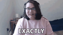 a woman wearing headphones and glasses is sitting in front of a computer screen and saying exactly .